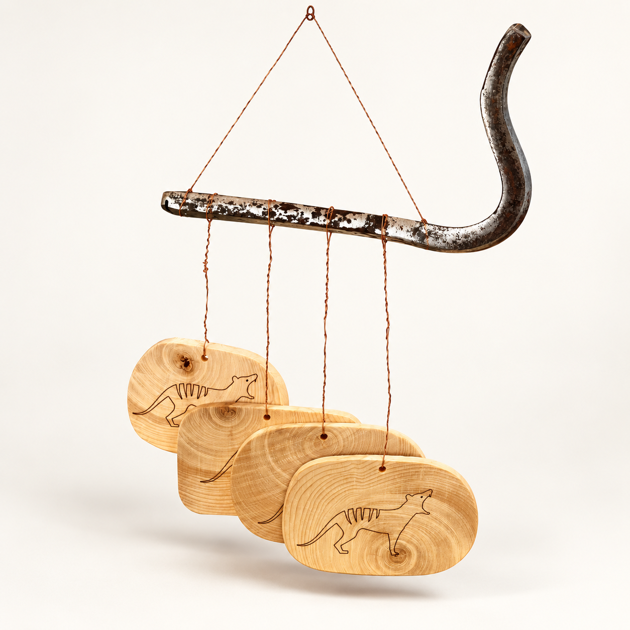 Huon pine wind chime with thylacine details suspended by fine copper wire from an old railway dog spike